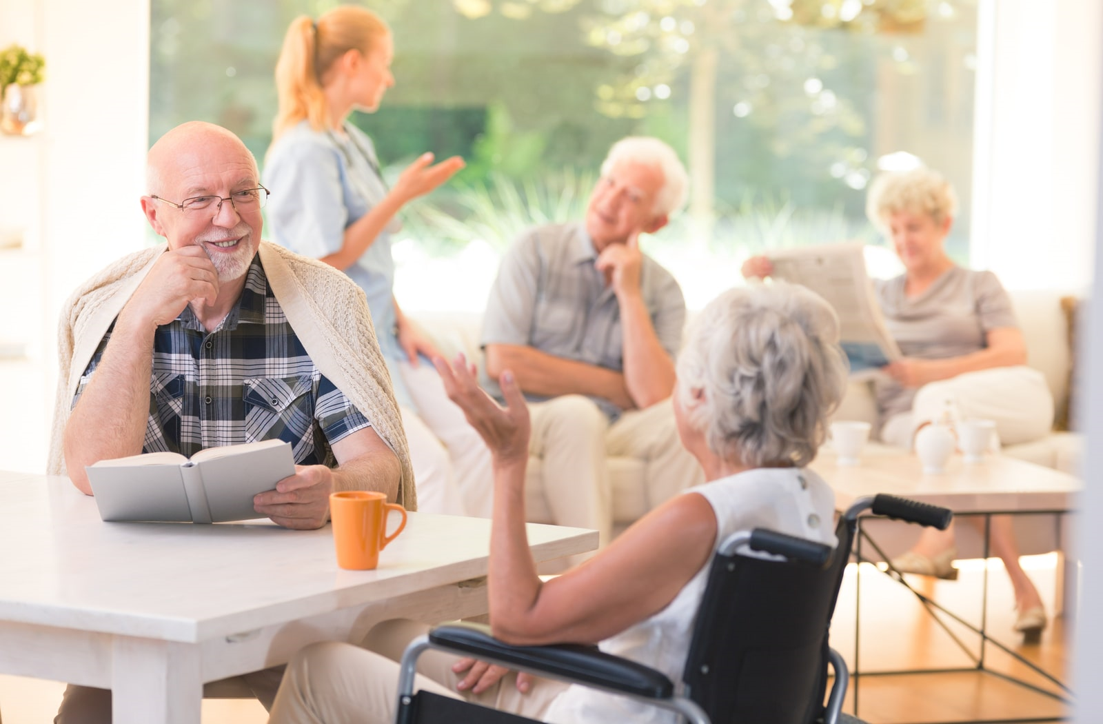 Elders sitting at table together discussing amongst each other.