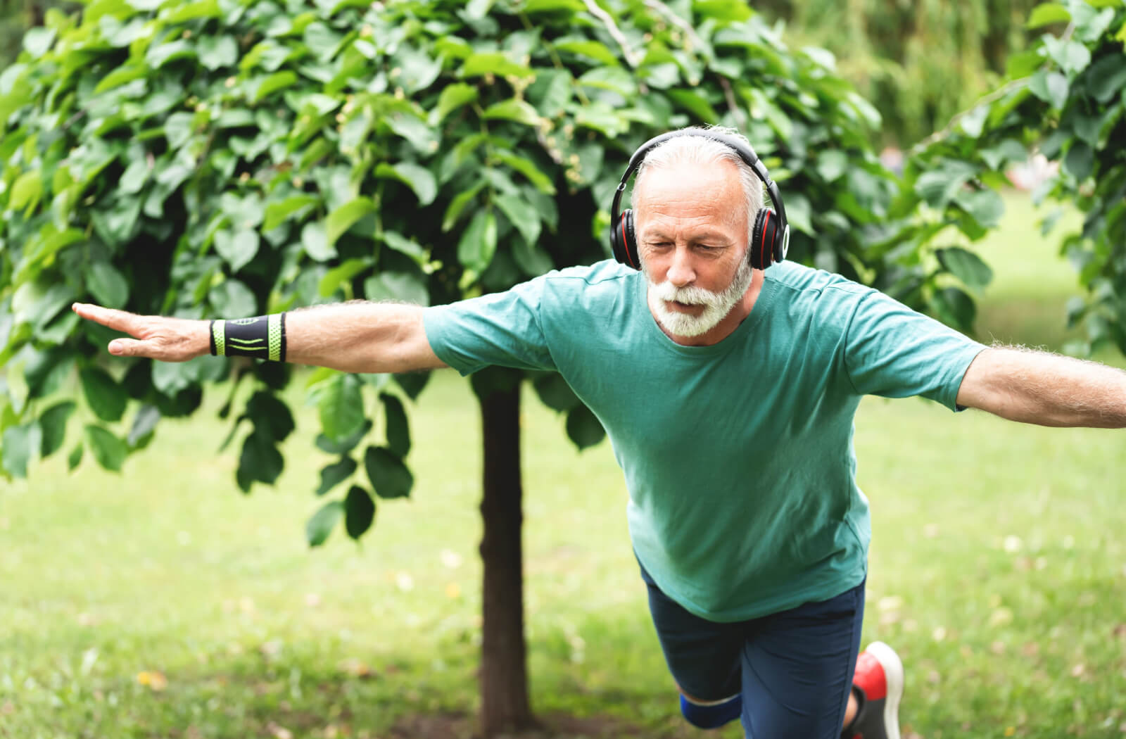 a senior man balancing on one leg