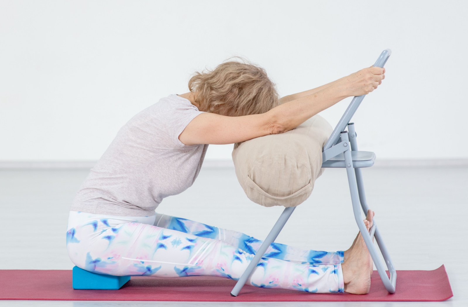 An older adult practices chair yoga as a way of staying active with limited mobility.