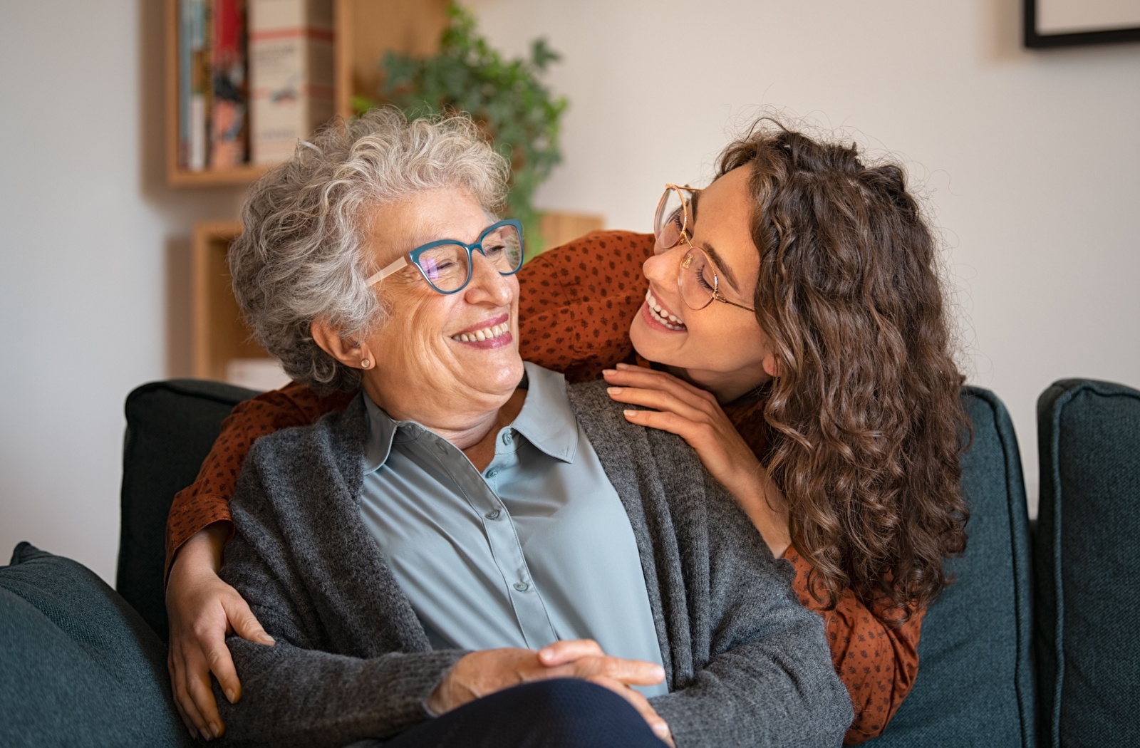 An adult child lovingly embracing a happy loved one in assisted living.